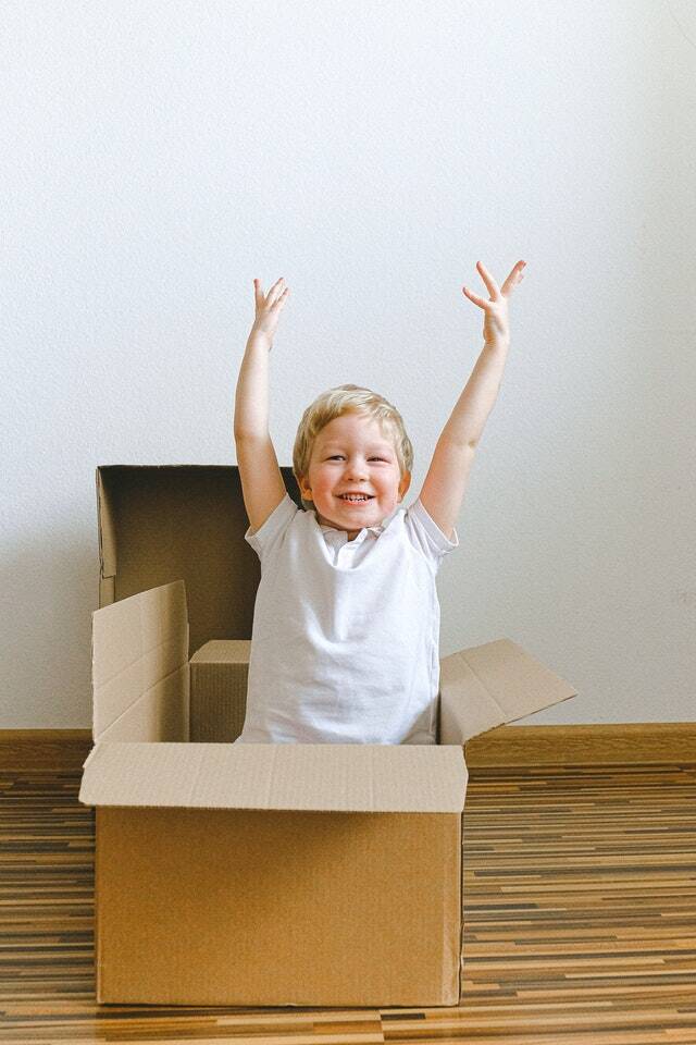 Move Out Cleaning Service - Green USA Cleaning Company - Photo of boy coming out of a cardboard box